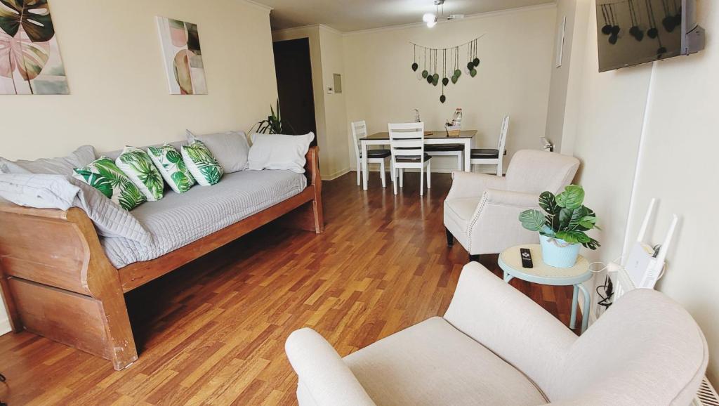 a living room with a couch and chairs and a table at Departamento Central para 7 personas con estacionamiento in Temuco