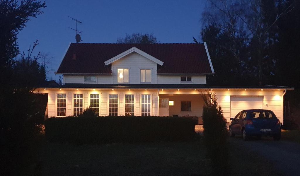 a house with a car parked in front of it at night at Landvetter Airport B&B and Parking in Härryda