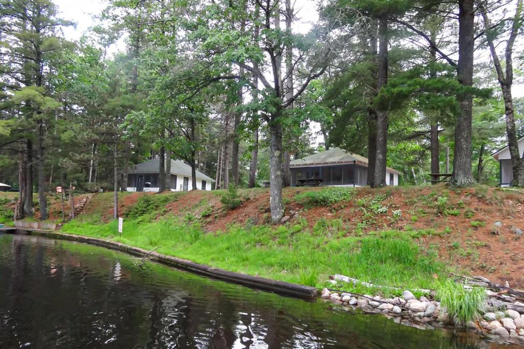 een huis op een heuvel naast een waterlichaam bij Fishermans Cottage in Manitowish Waters