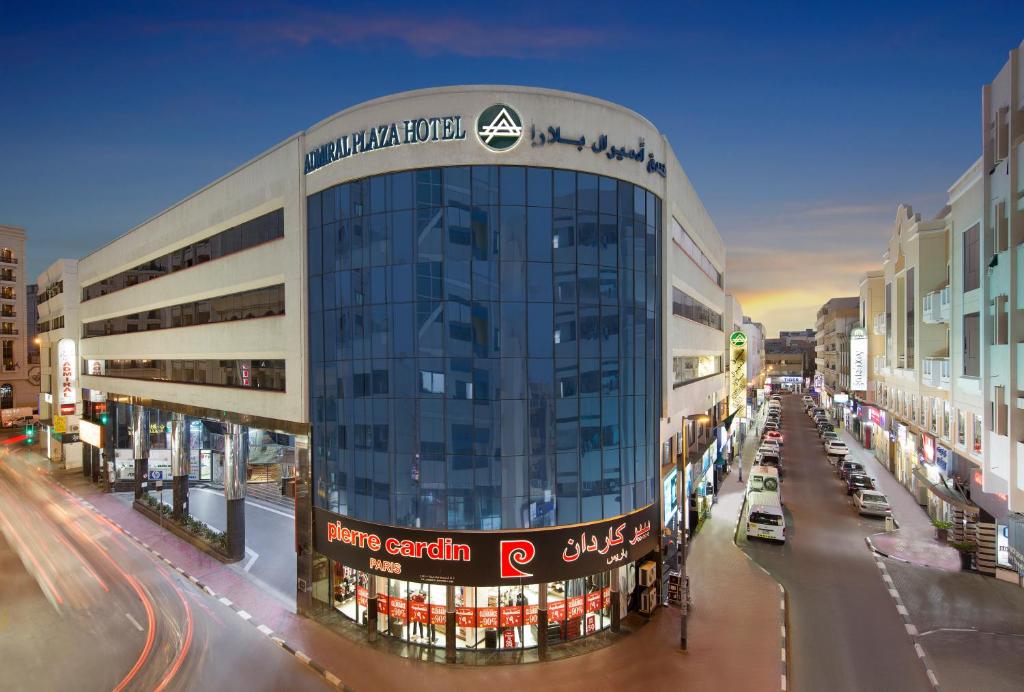 فندق ادميرل بلازا في دبي: مبنى زجاجي كبير على شارع المدينة وبه سيارات