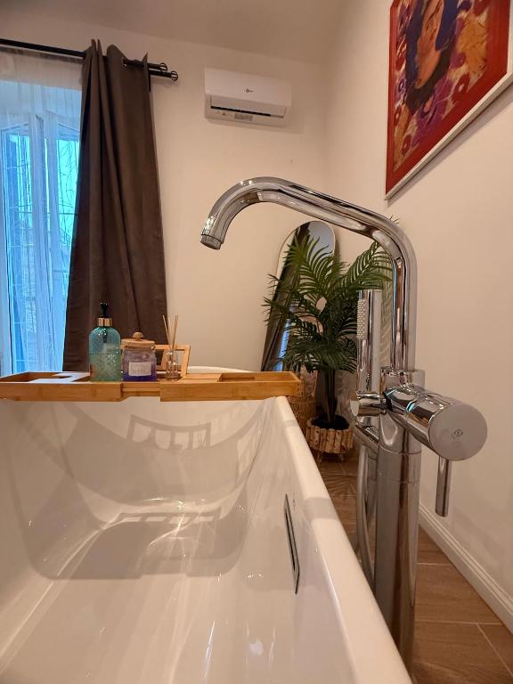 e bagno con vasca bianca e rubinetto. di Maison Frida • Tivoli a Tivoli