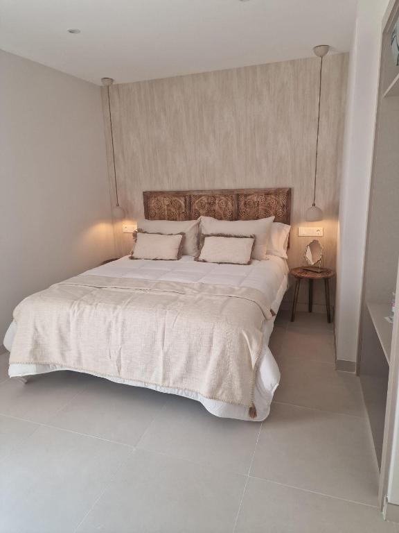 a bedroom with a large white bed with two pillows at La Posada del Olivar in Baena