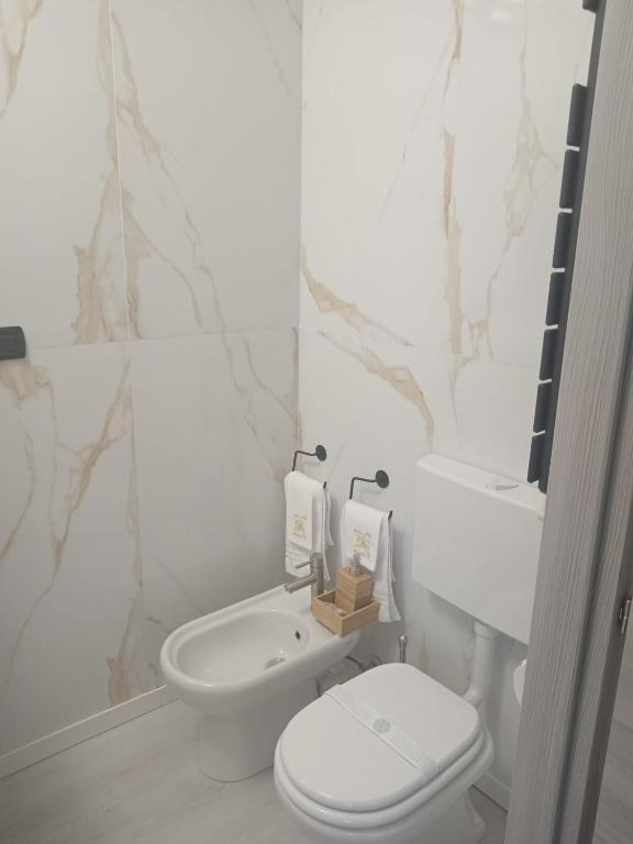biała łazienka z toaletą i umywalką w obiekcie Hotel Baiardo w mieście Romagnano Sesia