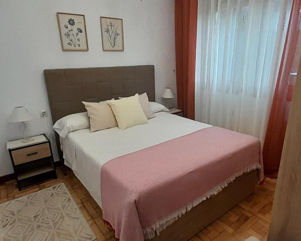sypialnia z dużym łóżkiem i różowym kocem w obiekcie Apartamento Sobrevilla SDR IV Sardinero w mieście Santander
