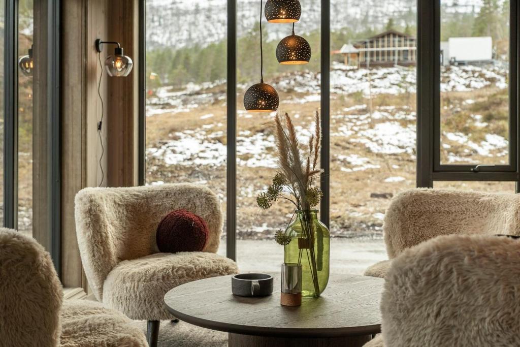 a living room with chairs and a table and a window at Hydla Mountain Lodge in Stryn
