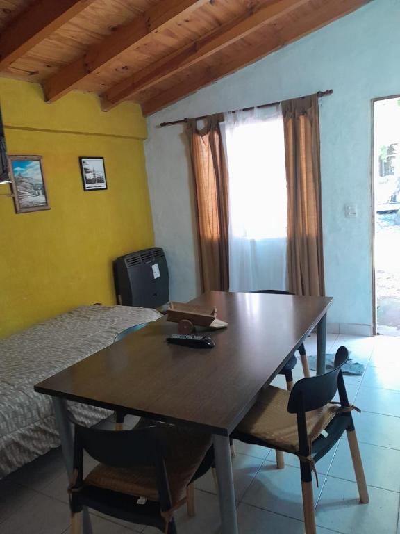 mesa de comedor con 2 sillas y 1 cama en Casita Roxy, en San Carlos de Bariloche