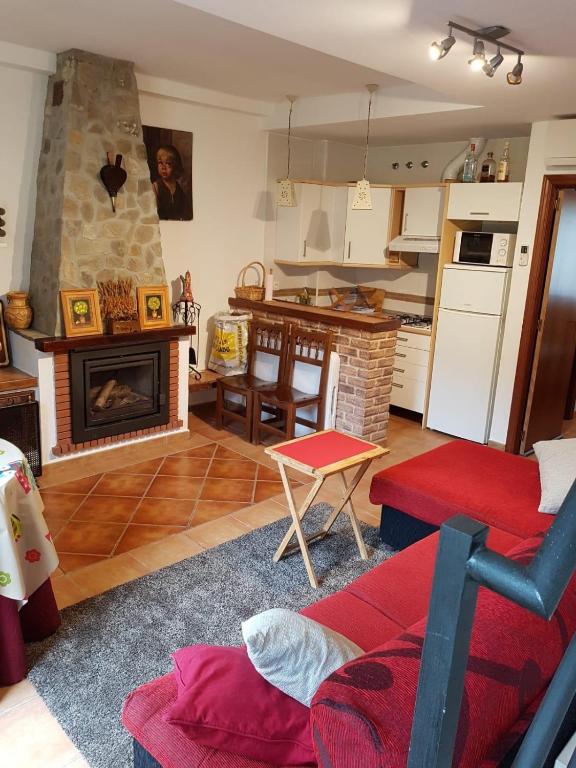 a living room with a fireplace and a kitchen at El Bosque Rural House in El Bosque