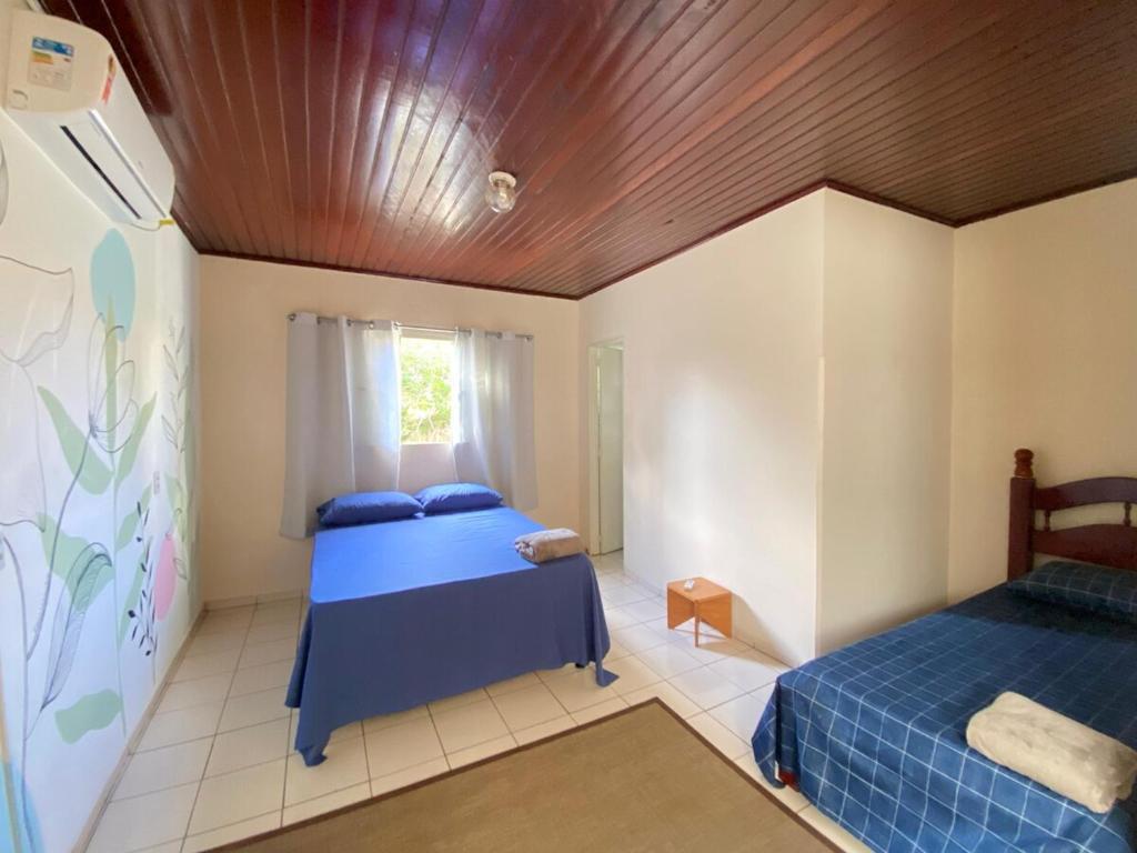 ein Schlafzimmer mit zwei Betten und einer Holzdecke in der Unterkunft Casa Vila Verde RIO VERDE GOIÁS in Rio Verde