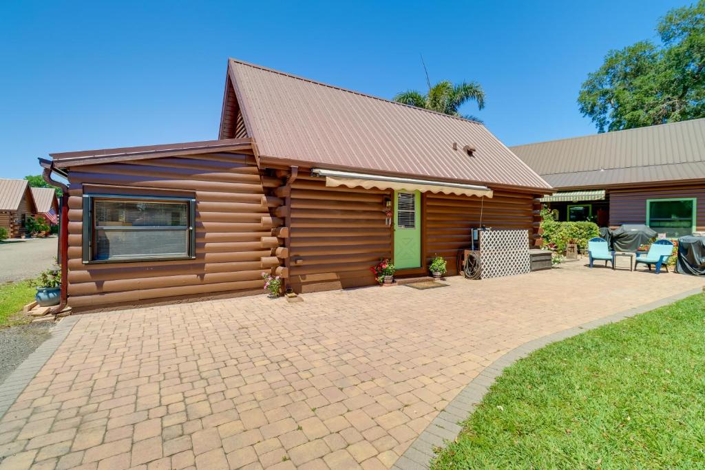a log cabin with a patio in front of it at Cabin with Boat Launch and Pool Access in Okeechobee in Okeechobee