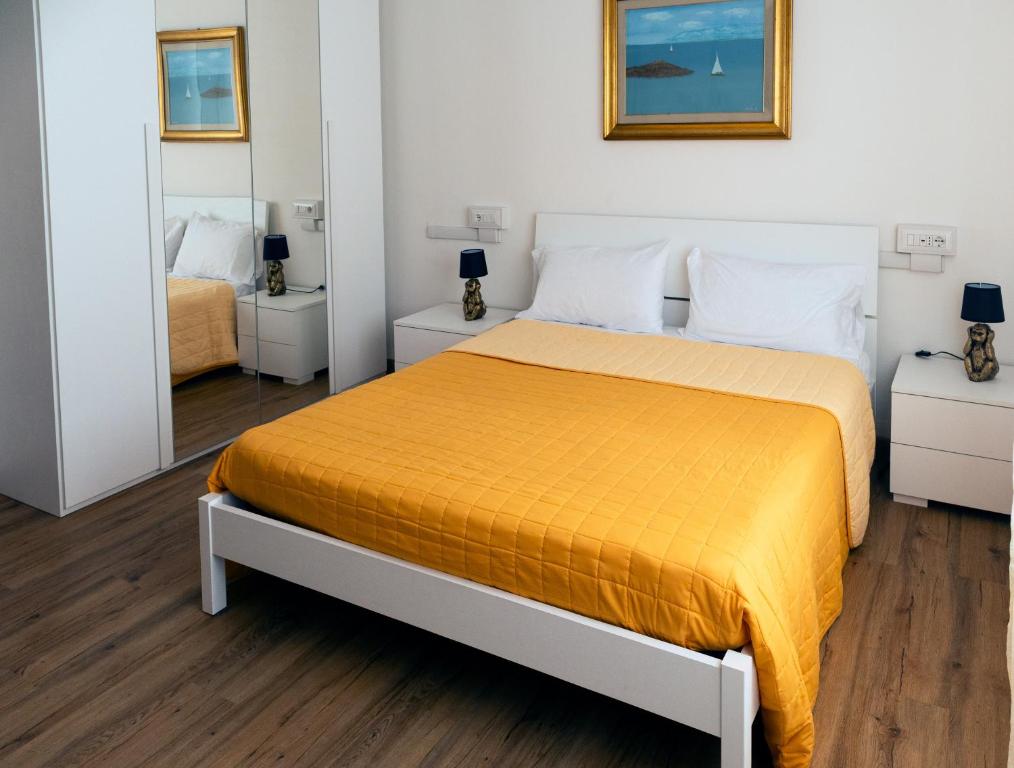 a bedroom with a bed with a orange bedspread at Dormen in Guspini