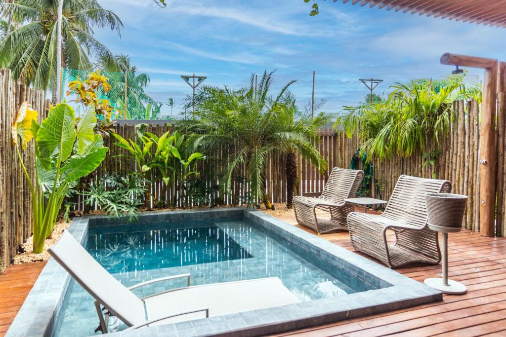 a swimming pool on a deck with chairs and a fence at Casa Bangalô dos Milagres in Passo de Camarajibe