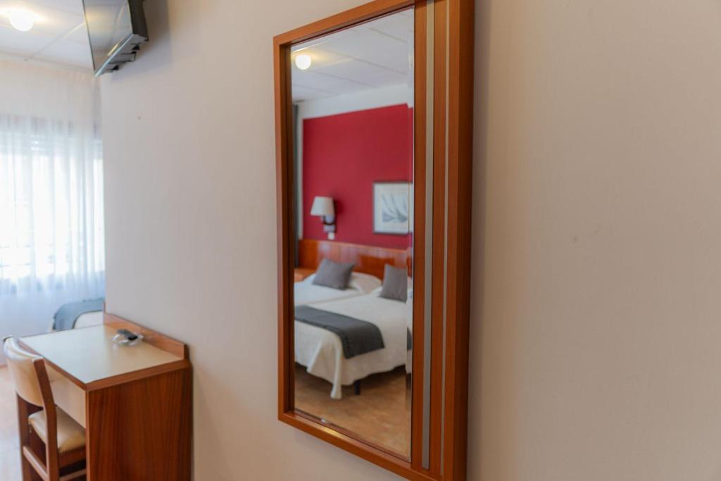 a bedroom with a bed and a mirror at Hostal Regina in Blanes