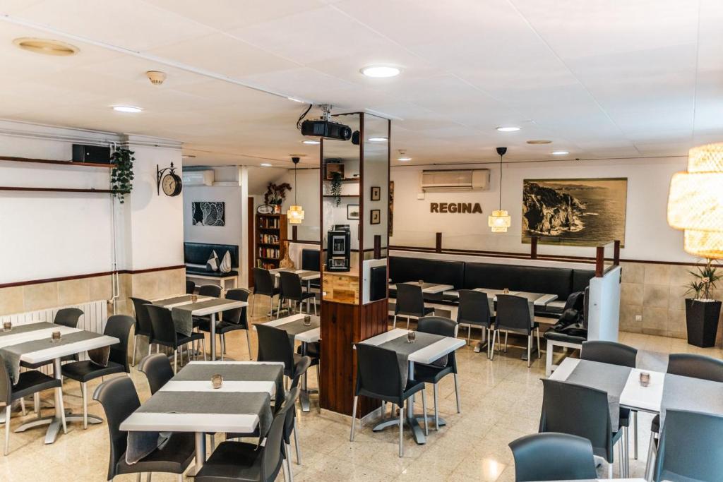 a restaurant with tables and chairs in a room at Hostal Regina in Blanes