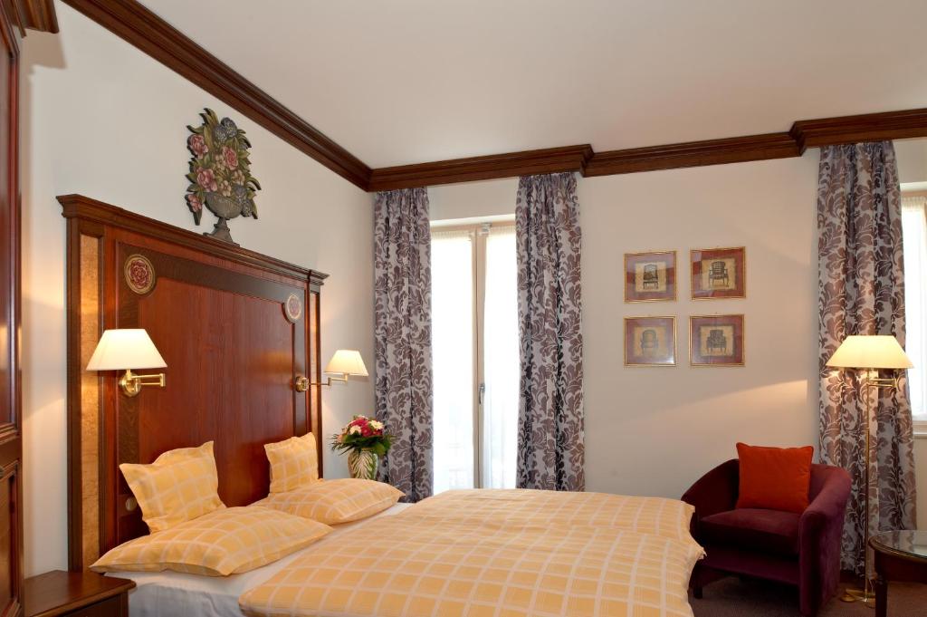 a bedroom with a bed and a chair at Chez Jean in Saverne