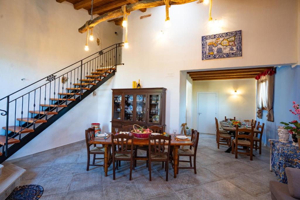 a dining room with a table and chairs and a staircase at Rooms Parrinelli in Partinico