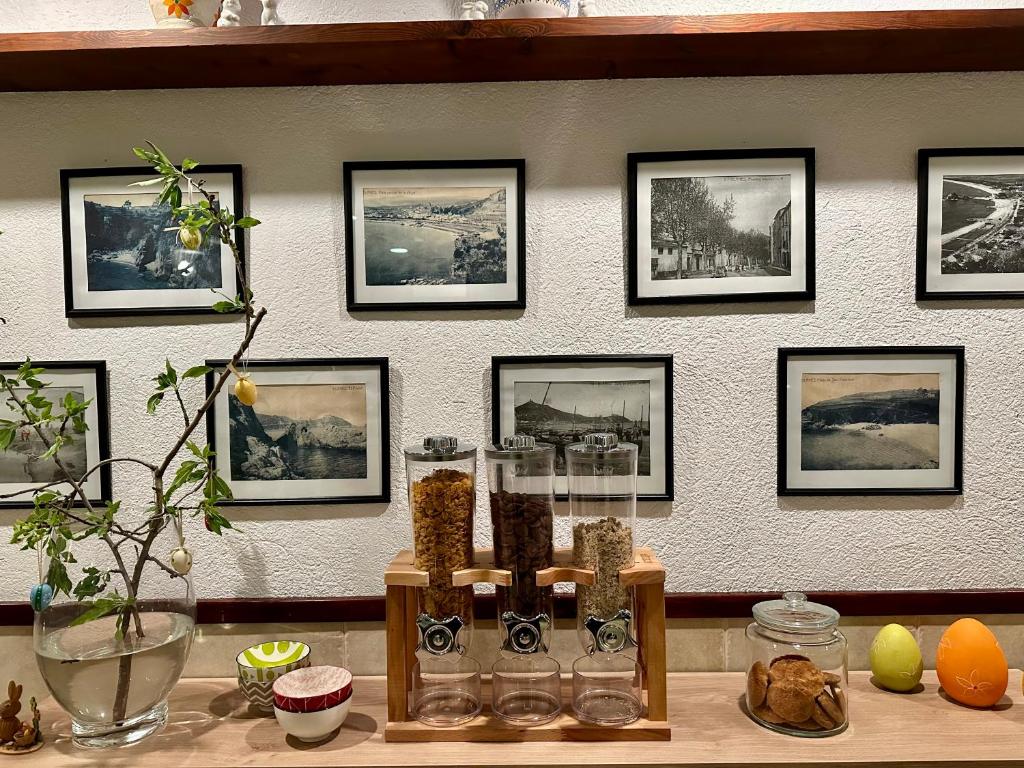 a wall with framed pictures on a wall with a table at Hostal Regina in Blanes