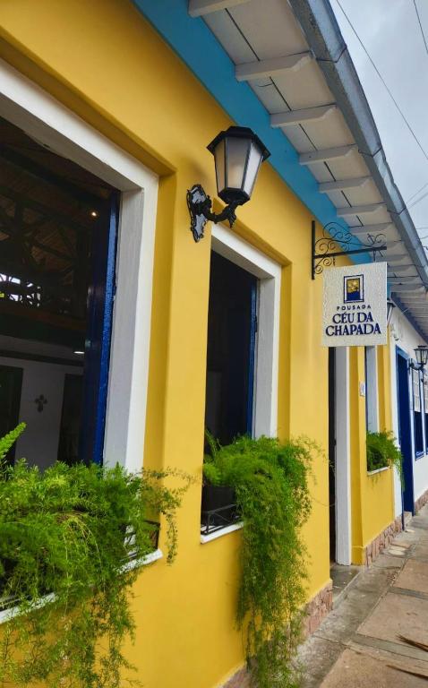 a yellow building with a street sign on it at Pousada Céu da Chapadha in Mucugê