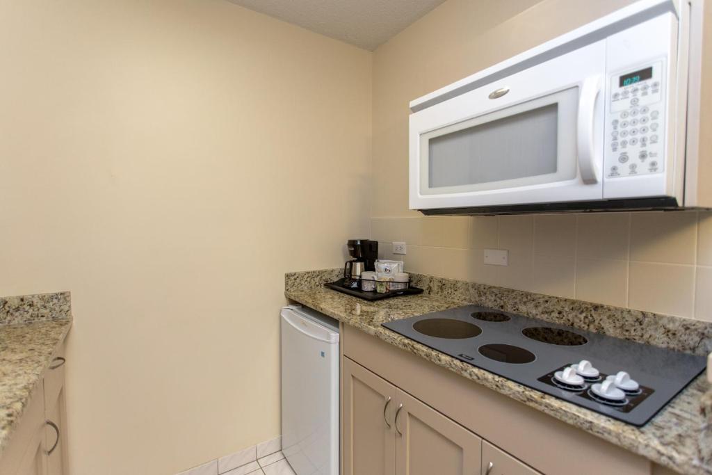 a kitchen with a microwave and a stove at Campus Tower Suite Hotel in Edmonton