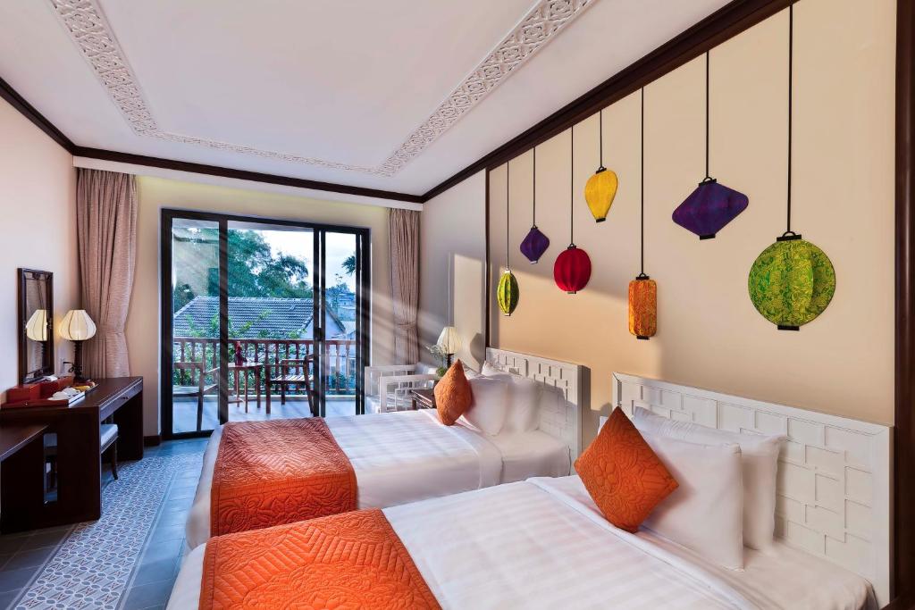 Giường trong phòng chung tại Cozy Original Hoi An Hotel