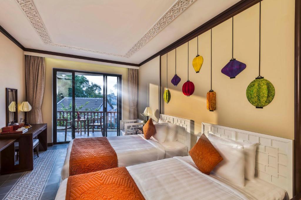 Giường trong phòng chung tại Cozy Original Hoi An Hotel