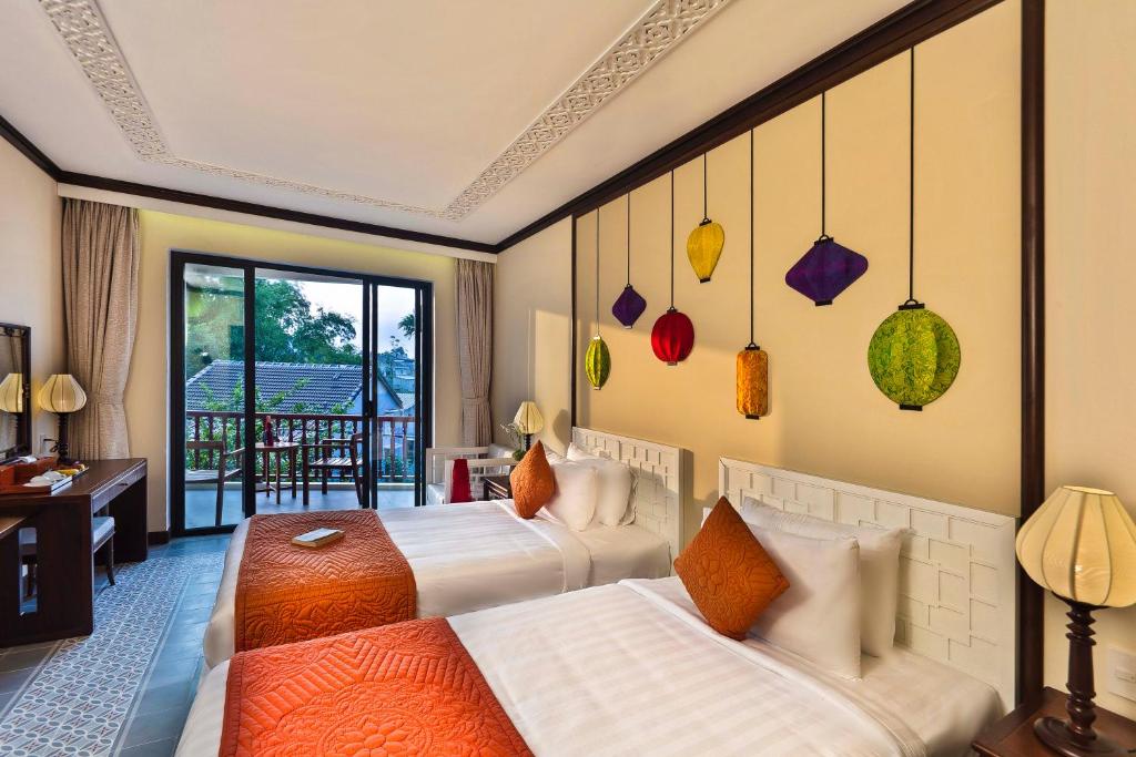 Giường trong phòng chung tại Cozy Original Hoi An Hotel