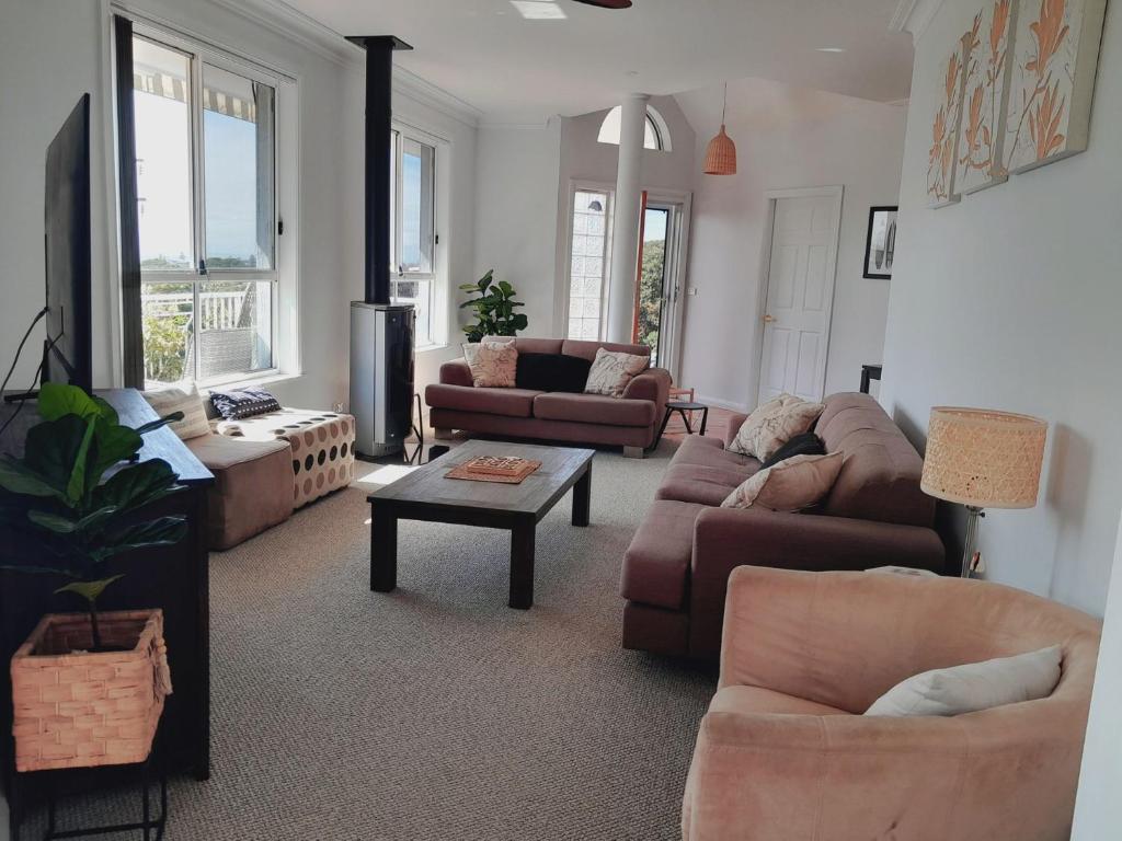 a living room with couches and a table at Breeze Kiama in Kiama