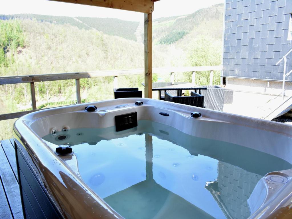 eine Badewanne mit Bergblick in der Unterkunft Lake-view apartment with sauna, hot tub in Grand Coo