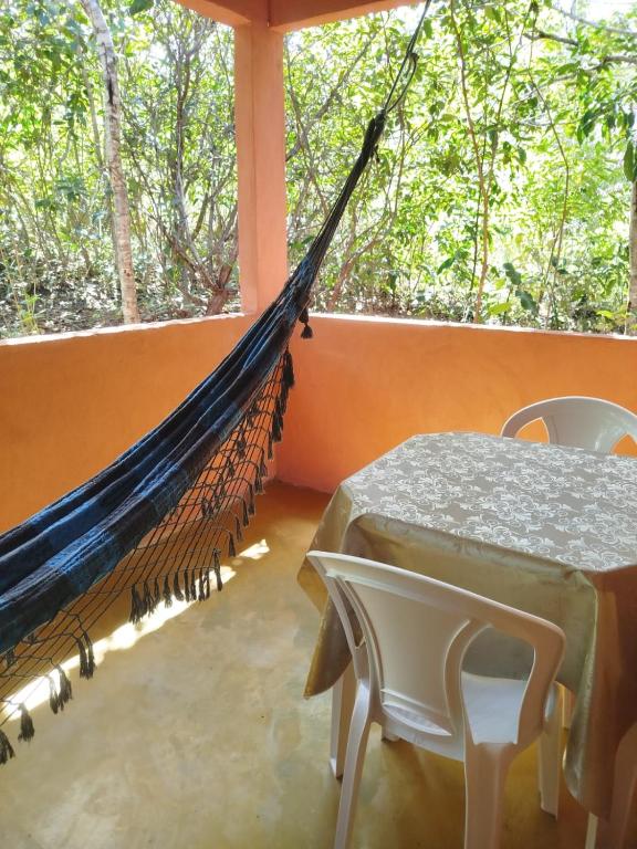 a hammock in a room with a table and chairs at Chalé do Ypê 2 in Pirenópolis
