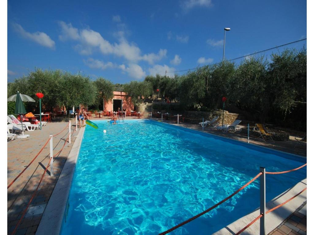 a large blue swimming pool with people in it at Studio für 4 Personen in Imperia in Imperia