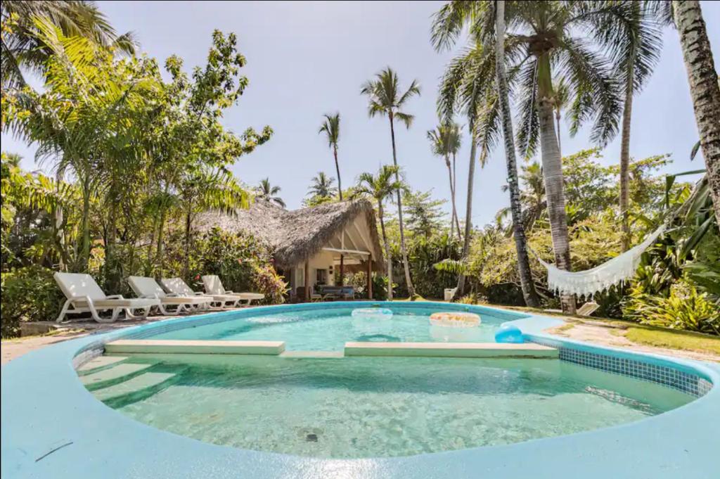 une piscine dans un complexe hôtelier avec des palmiers dans l'établissement Caribbean Beach Villa Playa Bonita Las Terrenas, à Las Terrenas