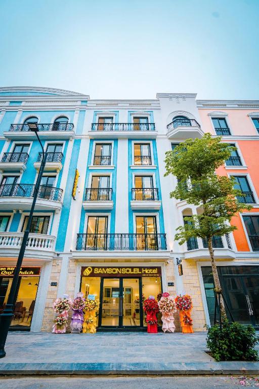 a large building with flowers in front of it at Samson Soleil Hotel in Sầm Sơn