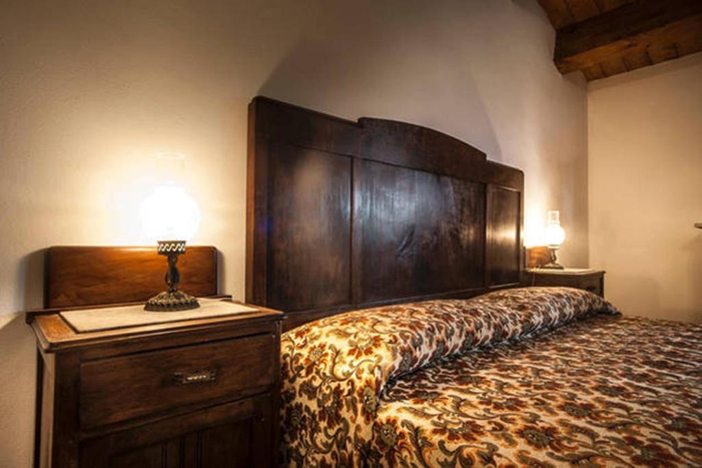 una camera da letto con un grande letto con una grande testiera in legno di Agriturismo Miracco Atanasio Franco "Il Maniero" a Santa Sofia dʼEpiro