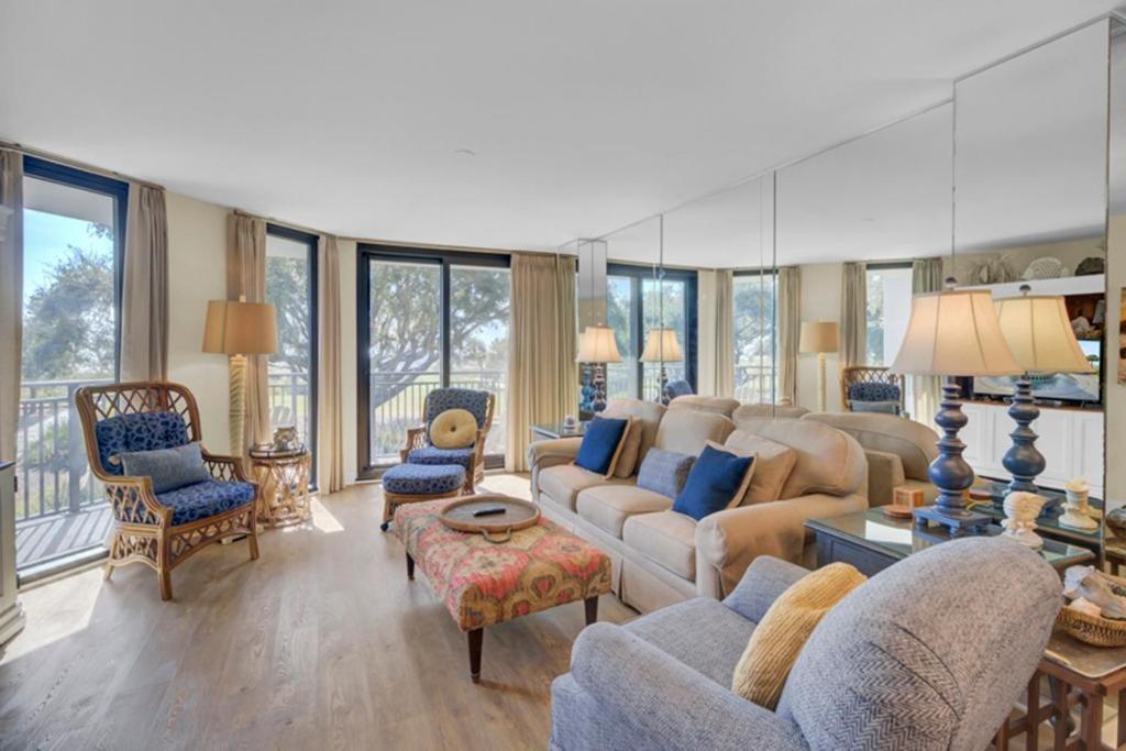 a living room with couches and chairs and windows at Shipwatch 104A by Wild Dunes, Oceanfront Condo in Isle of Palms