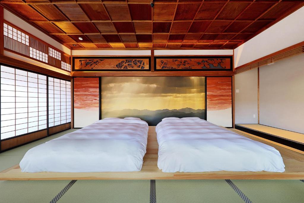 a bedroom with two beds in a room at YASUYA-yasuya- in Yasugi