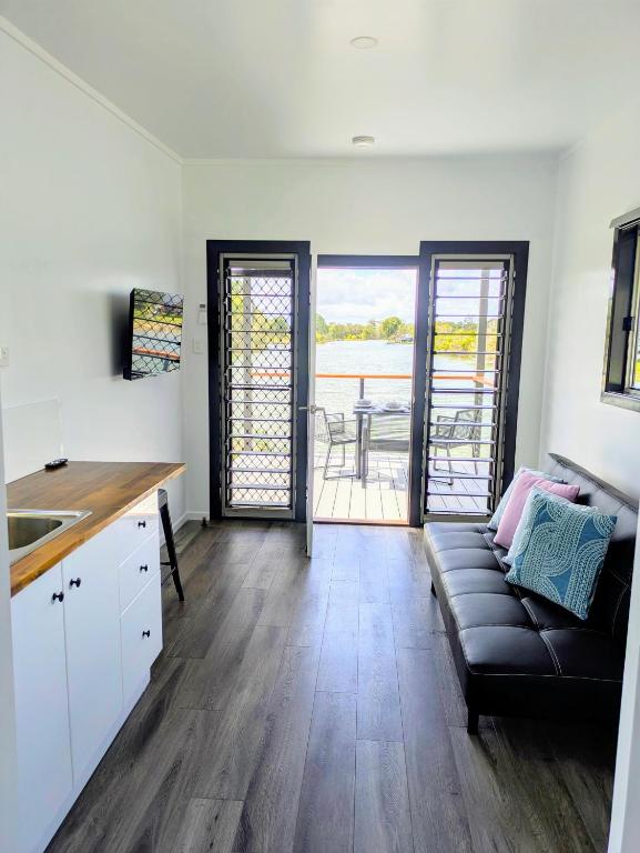 a kitchen and living room with a couch and a table at Trinity Islands Holiday Park - Cabin Accommodation in Burrum Heads