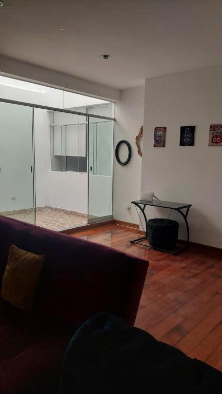 a living room with a table and a glass wall at Depa Excelente Vintage in La Molina