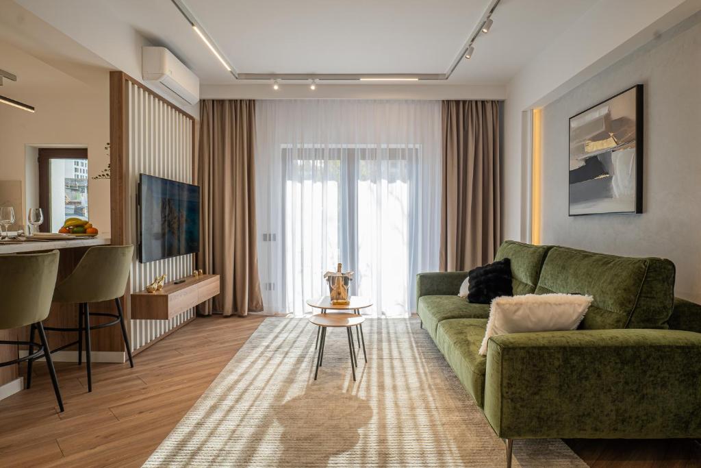 a living room with a green couch and a table at CHANTTAL Luxury - AMZEI in Bucharest