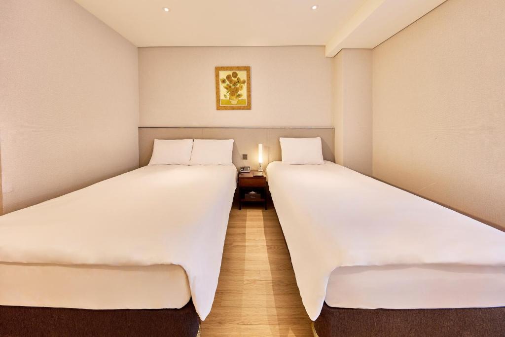 Postel nebo postele na pokoji v ubytování Hotel Thomas Myeongdong
