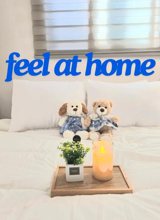 two teddy bears sitting on a bed with a candle at feel at Home in Incheon