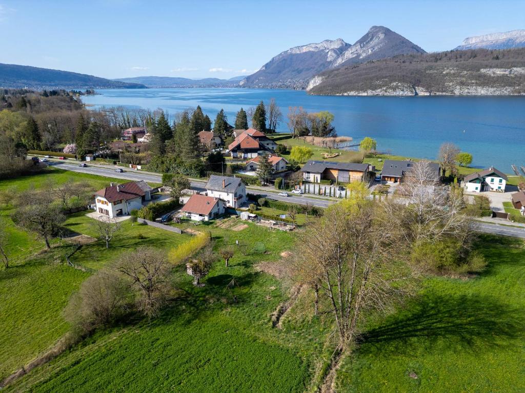 - une vue aérienne sur une maison à côté d'un lac dans l'établissement Maison jardin proximité plage, à Duingt