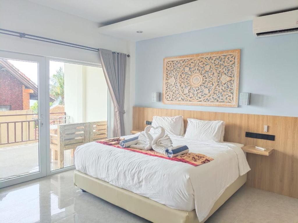 a bedroom with a large bed and a balcony at Solaluna Beach Homestay in Amed