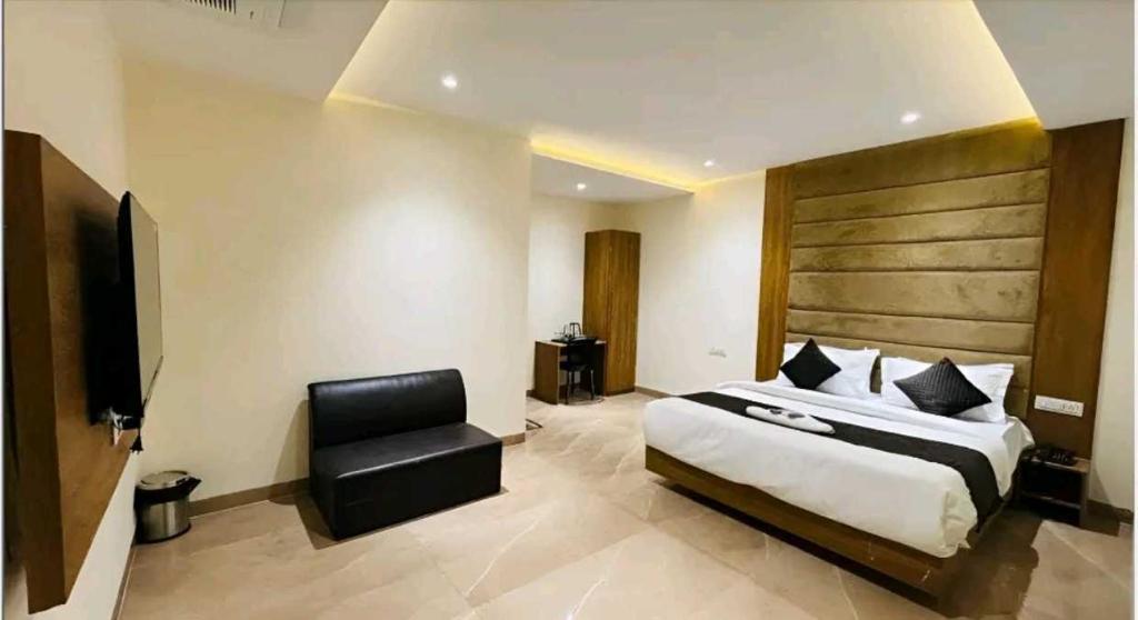 a hotel room with a bed and a chair at Townhouse Bargi Hills Formerly Hotel Sharma in Jabalpur