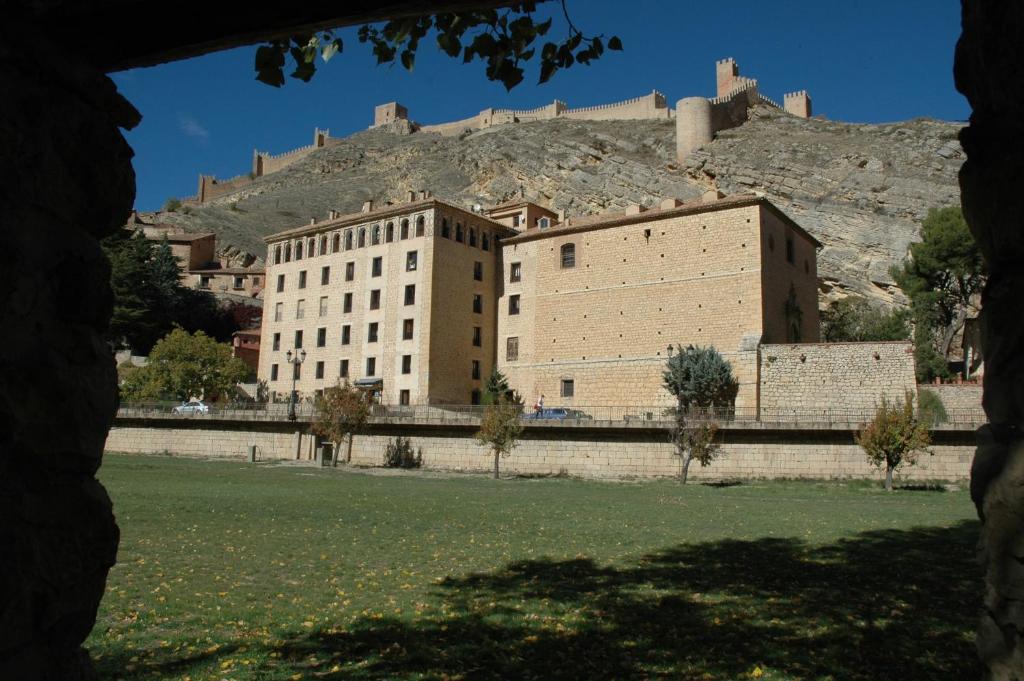 un gran edificio con un castillo en la cima de una colina en Hotel Arabia en Albarracín