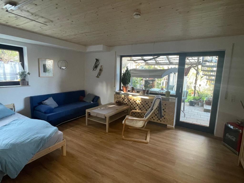 a bedroom with a blue couch and a living room at Glücksmomente in Wolfegg