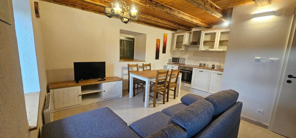 a living room with a couch and a table and a kitchen at Country house Viskic in Supetarska Draga