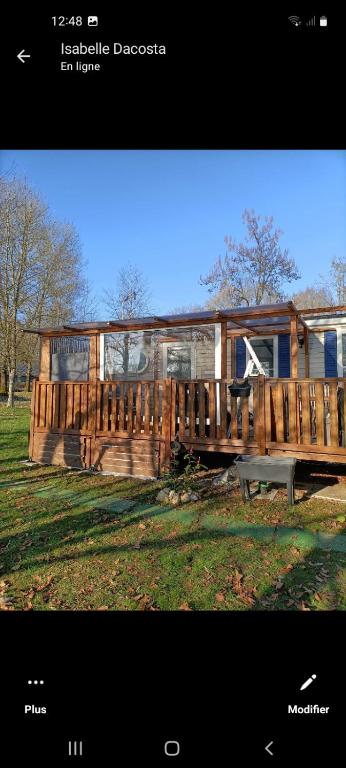 une maison en bois avec un banc dans un champ dans l'établissement Mobil-home emplacement 1, à Le Chesne