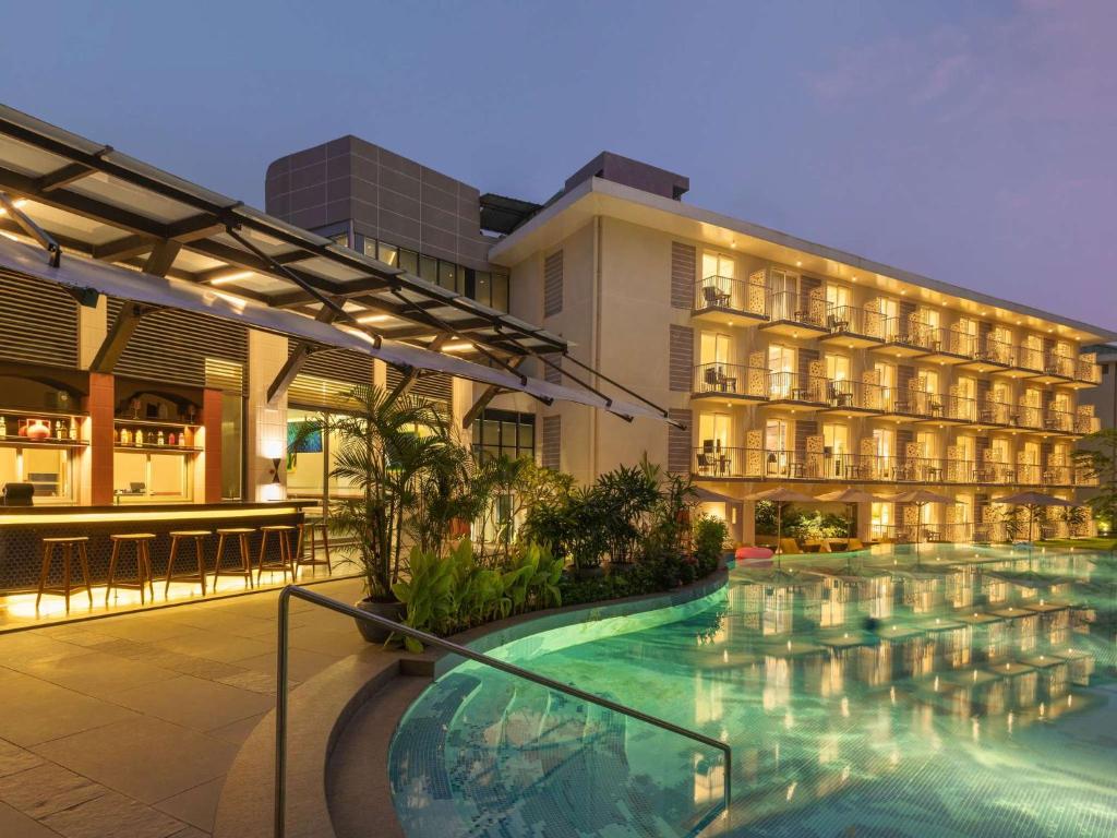 un hotel con piscina frente a un edificio en ibis Styles Goa Vagator - An Accor Brand, en Vagator