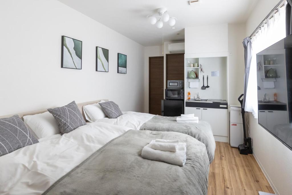 Un dormitorio blanco con una cama grande y una cocina. en Ocean 西九条, en Osaka