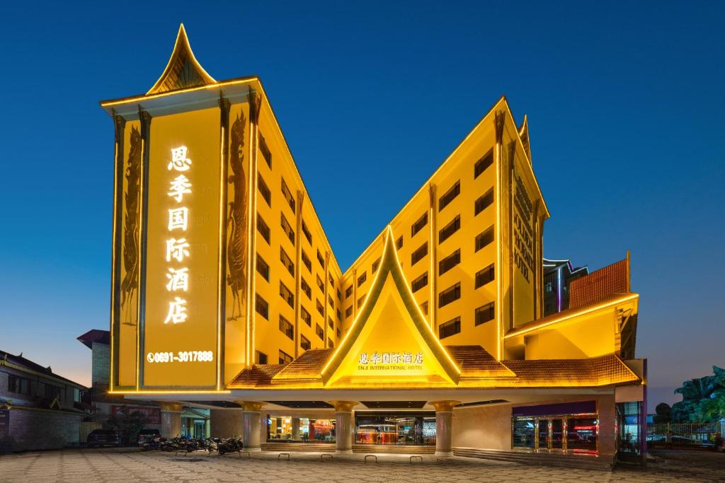 景洪市西双版纳景洪恩季国际酒店的一座黄色的大建筑,写着