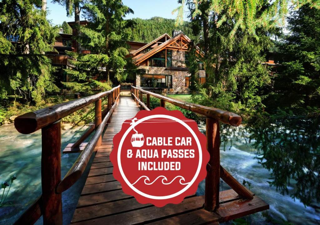 a sign on a wooden bridge in front of a cabin at Hotel Tri Studničky - Adult friendly in Demanovska Dolina